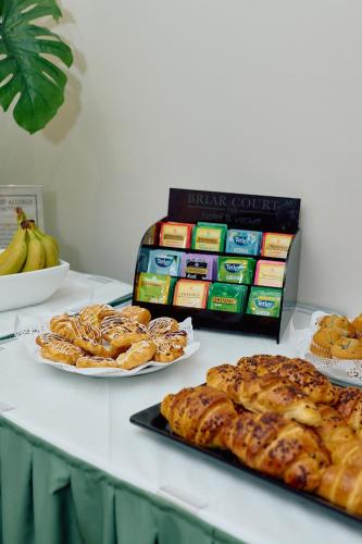 a table topped with plates of pastries and a box of cookies at The Briar Court Hotel in Huddersfield