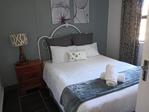 a bedroom with a bed with white towels on it at Caribe Accommodation and Conferences in Pietermaritzburg