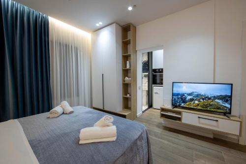 a bedroom with a bed and a flat screen tv at Niki’s Apartments in Tirana