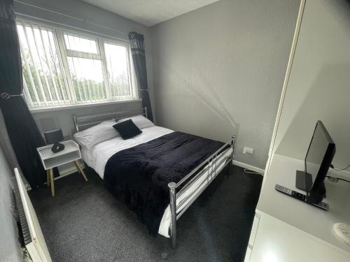 a small bedroom with a bed and a television at Comfy One Bedroom Apartment in Darlaston