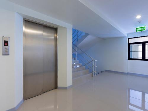 a metal elevator in a building with a staircase at HOP INN Kanchanaburi Building A in Kanchanaburi