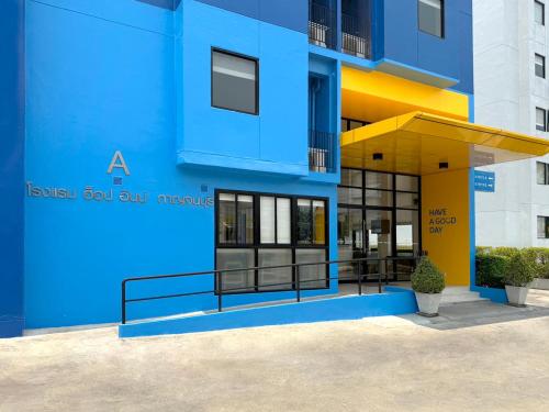 a blue building with a yellow and blue facade at HOP INN Kanchanaburi Building A in Kanchanaburi