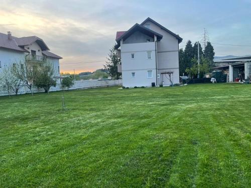 a large grassy yard with a white house at Villa ED in Sarajevo