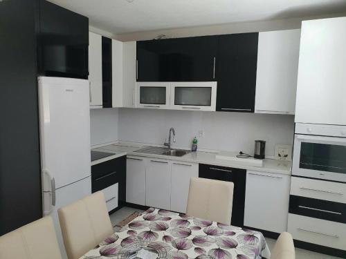 a kitchen with white cabinets and a table and chairs at Villa ED in Sarajevo