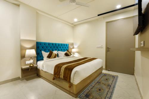 OPO Hotels D'or في نيودلهي: غرفة نوم مع سرير كبير مع اللوح الأمامي الأزرق