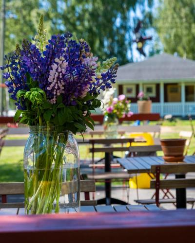 un vase rempli de fleurs violettes assises sur une table dans l'établissement Merry Camping, à Merikarvia