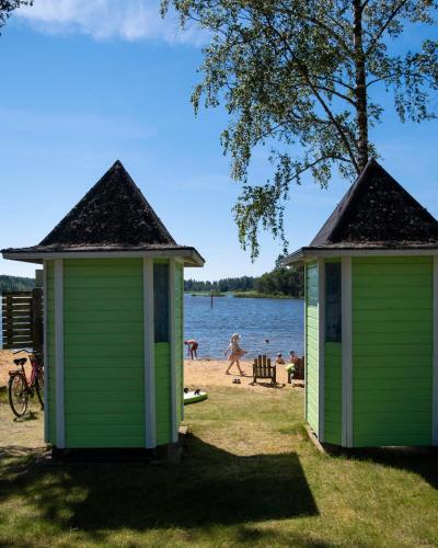 deux bâtiments verts sur la rive d’un lac dans l'établissement Merry Camping, à Merikarvia