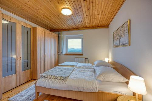 una camera con un grande letto e un soffitto in legno di Lovely Cottage Tilka - Happy Rentals a Novo Mesto
