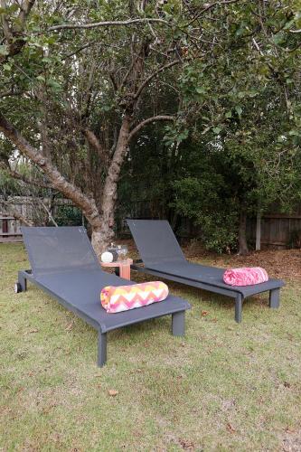 two beds sitting in the grass next to a tree at Mcrae retro beach house ! in McCrae