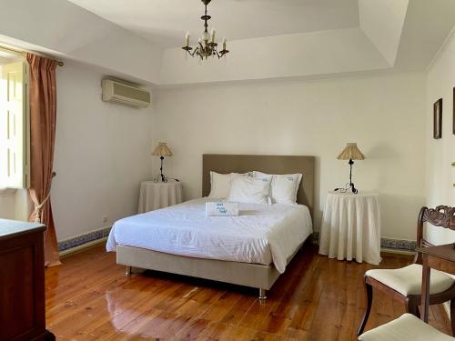 a bedroom with a white bed and two tables at Change The World - Solar de Alvega in Alvega