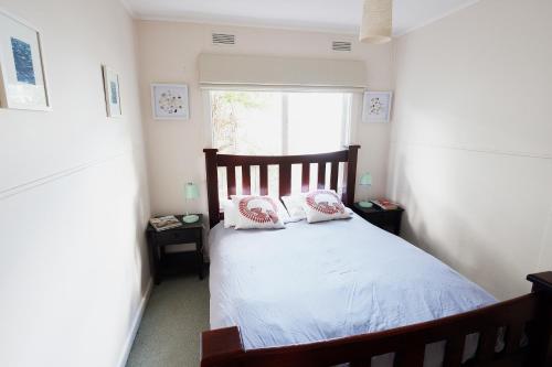 a bedroom with a bed with two pillows on it at Mcrae retro beach house ! in McCrae