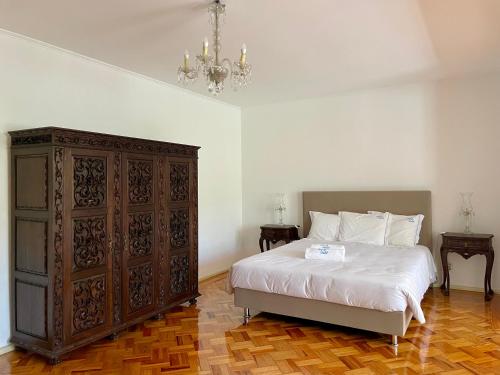 a bedroom with a bed and a large wooden cabinet at Change The World - Solar de Alvega in Alvega