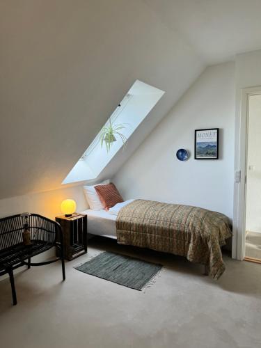 um quarto com uma cama e uma clarabóia em Ellens Have, Lejlighed Asta em Ebeltoft