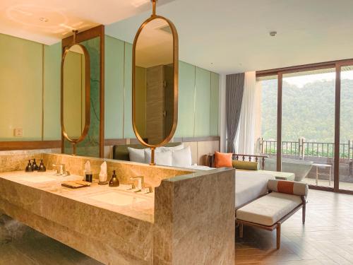 łazienka z 2 umywalkami i łóżkiem z lustrem w obiekcie Mandala Retreats Kim Bôi w mieście Hòa Bình