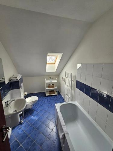 a bathroom with a tub and a toilet and a sink at Hotel Mlyn in Zavar