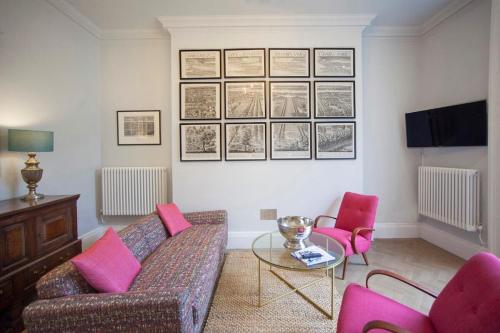 a living room with a couch and pink chairs at Stylish City Centre Apartment - Bath in Bath