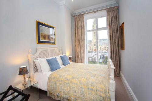 a bedroom with a bed and a large window at Stylish City Centre Apartment - Bath in Bath