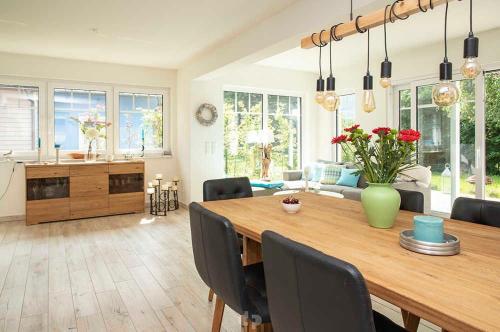 uma sala de jantar e sala de estar com uma mesa de madeira em Ferienhaus ELSA Kinder erst ab 12 em Dierhagen