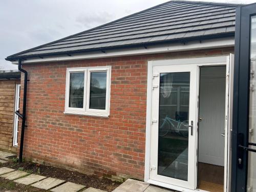 a red brick house with a white door at 1 Bed Room & Bathroom Garden No Kitchen in Stoke Poges