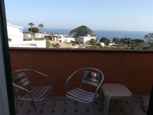 2 stoelen en een tafel op een balkon met uitzicht op de oceaan bij Casa La Perla in Ischia