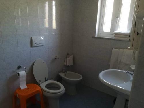 uma casa de banho branca com um WC e um lavatório em Casa La Perla em Ischia