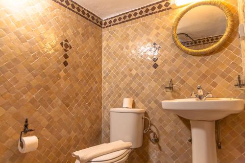 a bathroom with a toilet and a sink and a mirror at Riad Al Madina in Essaouira