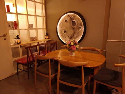 a dining room with a wooden table and chairs at Amsterdamned (อัมสเตอร์ดัมด์) in Bangkok