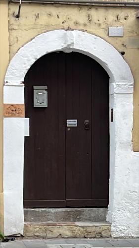a large brown door in a building with an arch at LA CASA DI Jo in Cosenza