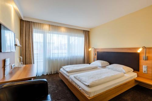 a bedroom with a large bed and a large window at Ott's Hotel Weinwirtschaft & Biergarten Weil am Rhein/Basel in Weil am Rhein