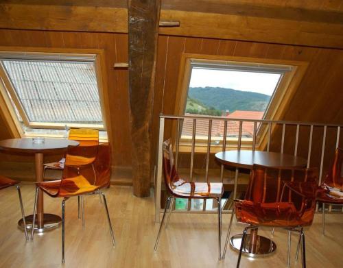 un comedor con 2 mesas y sillas y una ventana en Casa Aguerre, en Villanueva de Aézcoa