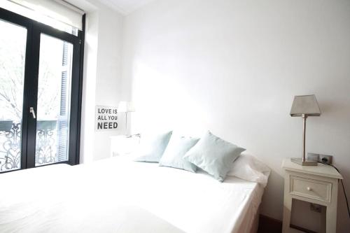 - une chambre avec un lit blanc et une fenêtre dans l'établissement Céntrico y amplio. Impecable. Restaurantes bares, à Saint-Sébastien
