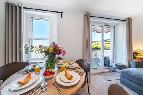 a dining room with a table with food on it at N° 31 The Salcombe in Salcombe