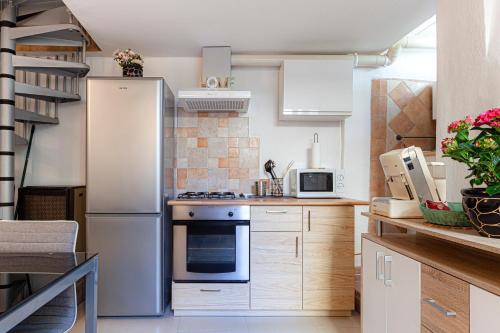 Una cocina con electrodomésticos blancos y gabinetes de madera. en Casetta della Posterna, en Spoleto