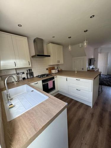 a kitchen with white cabinets and a counter top at Cosy Home In The Heart Of Sussex in Burgess Hill