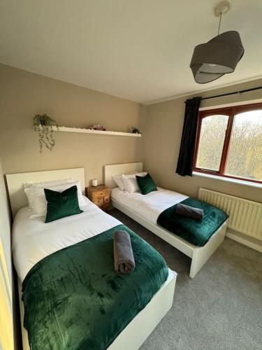 a bedroom with two beds and a window at Cosy Home In The Heart Of Sussex in Burgess Hill