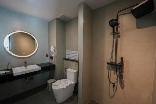 y baño con ducha, aseo y lavamanos. en โรงแรมออร่า สงขลา, en Hat Yai