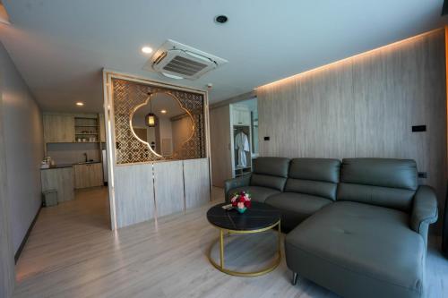 a living room with a couch and a table at โรงแรมออร่า สงขลา in Hat Yai