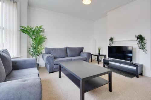 a living room with two couches and a tv at Ashley Road Apartment 3 in Poole
