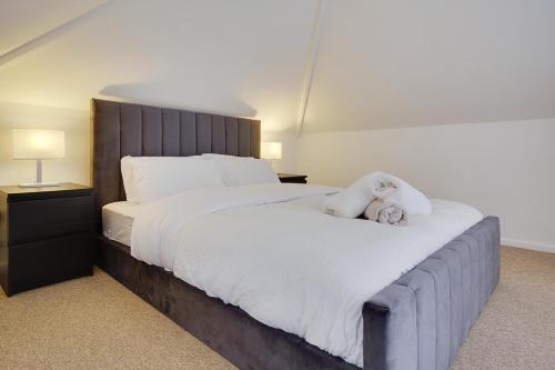 a bedroom with a large bed with a teddy bear on it at Ashley Road Apartment 3 in Poole