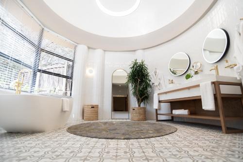 bagno con vasca, lavandino e specchio di Thaba Eco Hotel a Johannesburg
