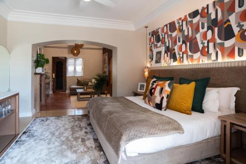 a bedroom with a large bed and a living room at Thaba Eco Hotel in Johannesburg