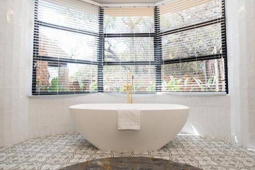 a white bath tub in a bathroom with a window at Thaba Eco Hotel in Johannesburg