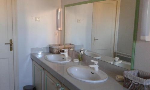 ein Badezimmer mit zwei Waschbecken und einem großen Spiegel in der Unterkunft Studio de Tourisme Tilleuls in Grenade-sur-lʼAdour