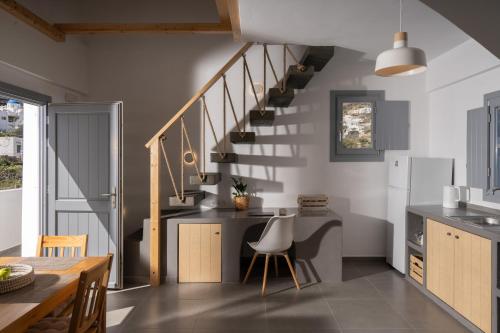 eine Küche mit einer Treppe mit einem Tisch und einem Esszimmer in der Unterkunft The Vine Suites in Vourvoúlos