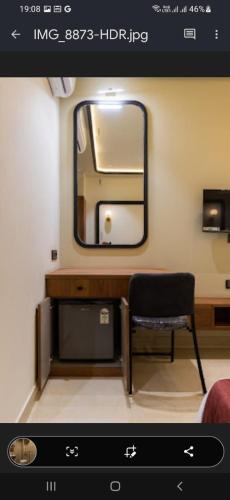 a bathroom with a mirror and a chair in a room at Vaibhavya Hotel & Restaurant udaipur in Udaipur