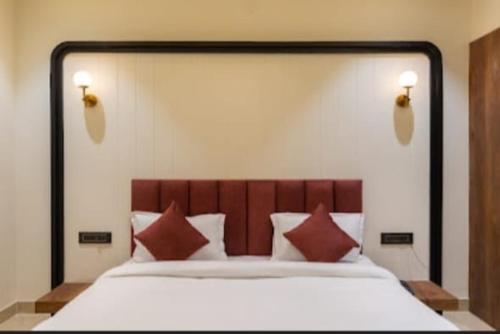 a bedroom with a large bed with red pillows at Vaibhavya Hotel & Restaurant udaipur in Udaipur