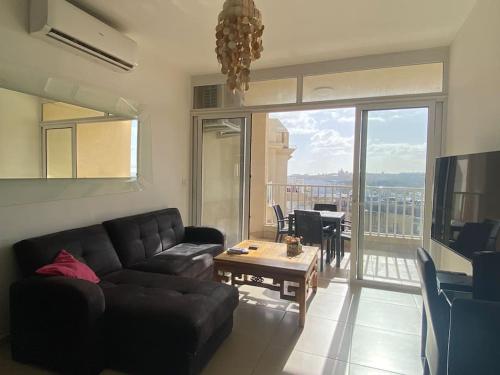 a living room with a black couch and a table at Central Sliema 3bdr. Apartment in Sliema
