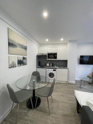 a kitchen and living room with a table and chairs at Chelsea Cloisters Serviced Apartments in London