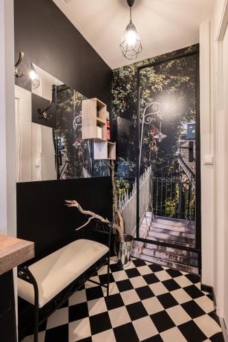 Cette chambre est dotée d'un sol en damier et d'une porte avec une fresque murale. dans l'établissement Atypique - Coeur de ville - Ecran géant - 2 pers, à Pau