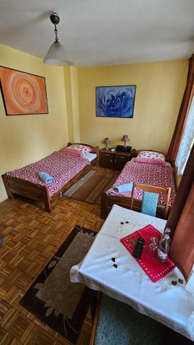 a room with two beds and a table at Zajazd-restauracja Zyga in Iwkowa